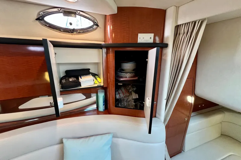Slide: The Image of Interior of 2004 Sea Ray 320 Sundancer with open cabinets and seating area. - 58