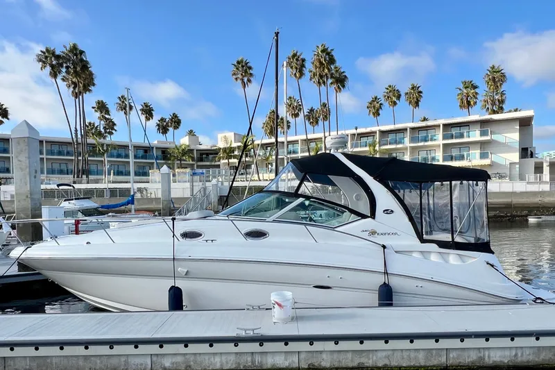 Slide: The Image of 2004 Sea Ray 320 Sundancer docked at marina with palm trees and buildings. - 6
