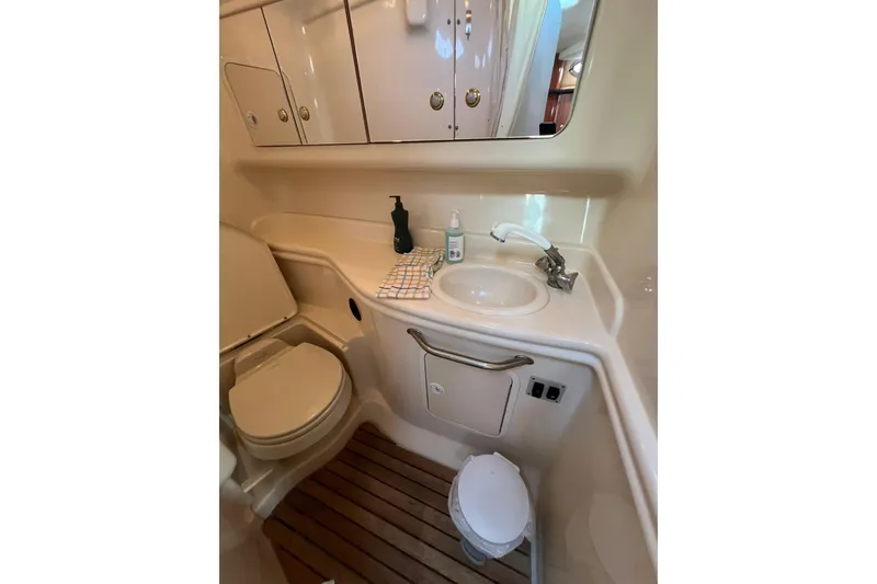 Slide: The Image of 2004 Sea Ray 320 Sundancer bathroom with sink, toilet, and wooden floor mat. - 63
