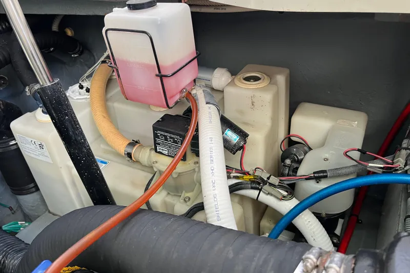 Slide: The Image of Engine compartment of a 2004 Sea Ray 320 Sundancer with visible fluid reservoirs and hoses. - 69