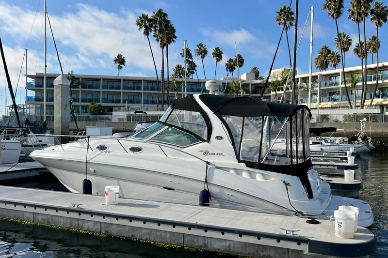 Slide: The Image of 2004 Sea Ray 320 Sundancer docked at marina with palm trees and buildings. - 7
