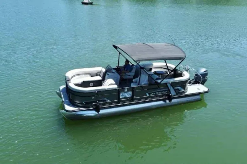 The Image of 2023 Starcraft EXS 3 pontoon boat on calm green water. - 1