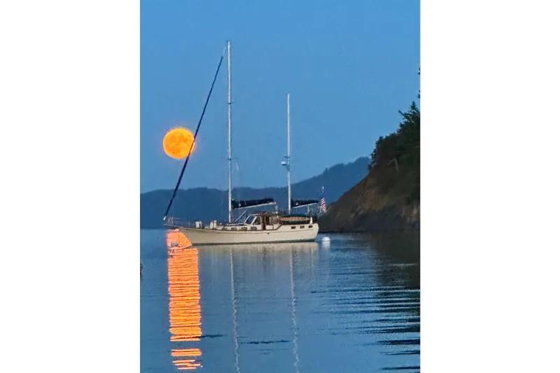 The Image of 1980 Nauticat Pilothouse sailboat on calm water with a full moon reflection. - 0
