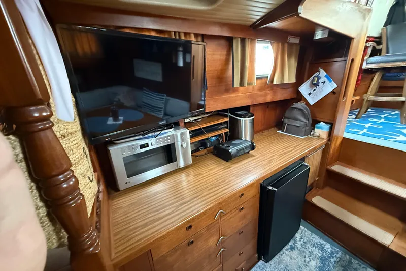 Slide: The Image of 1980 Nauticat Pilothouse interior with TV, microwave, and wooden cabinetry. - 10