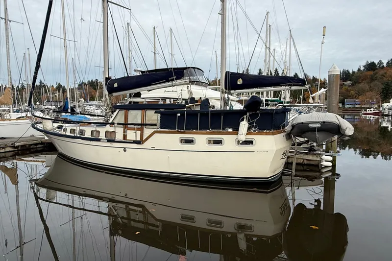 Slide: The Image of 1980 Nauticat Pilothouse sailboat docked in a marina, surrounded by other boats. - 22