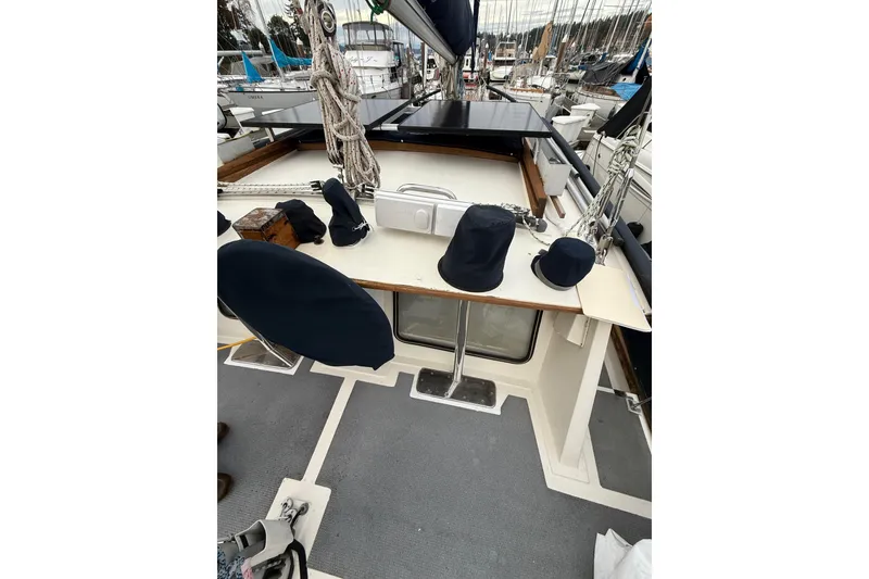 Slide: The Image of 1980 Nauticat Pilothouse deck with covered equipment and ropes in a marina setting. - 23