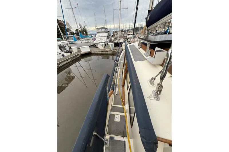 Slide: The Image of 1980 Nauticat Pilothouse sailboat docked in a marina, surrounded by other vessels. - 29