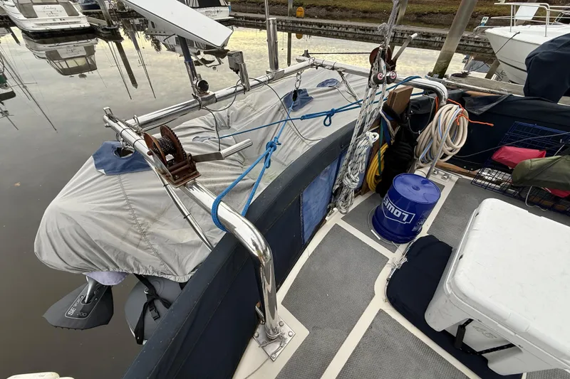 Slide: The Image of 1980 Nauticat Pilothouse boat deck with equipment, ropes, and covered outboard motor. - 32