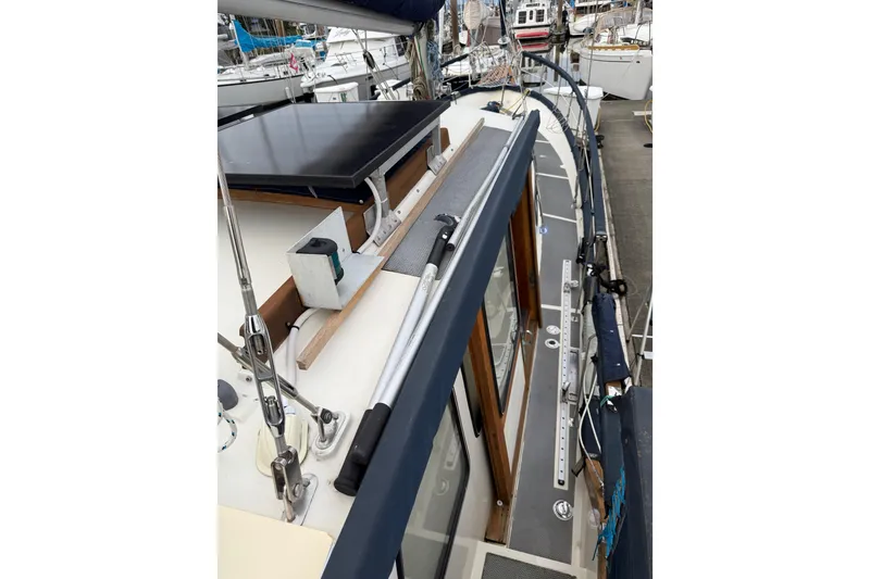 Slide: The Image of 1980 Nauticat Pilothouse sailboat deck with solar panel and railing in marina. - 35