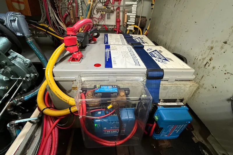 Slide: The Image of 1980 Nauticat Pilothouse engine room with battery and wiring setup. - 41