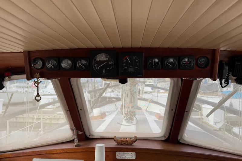 Slide: The Image of 1980 Nauticat Pilothouse interior with dashboard instruments and marina view. - 5