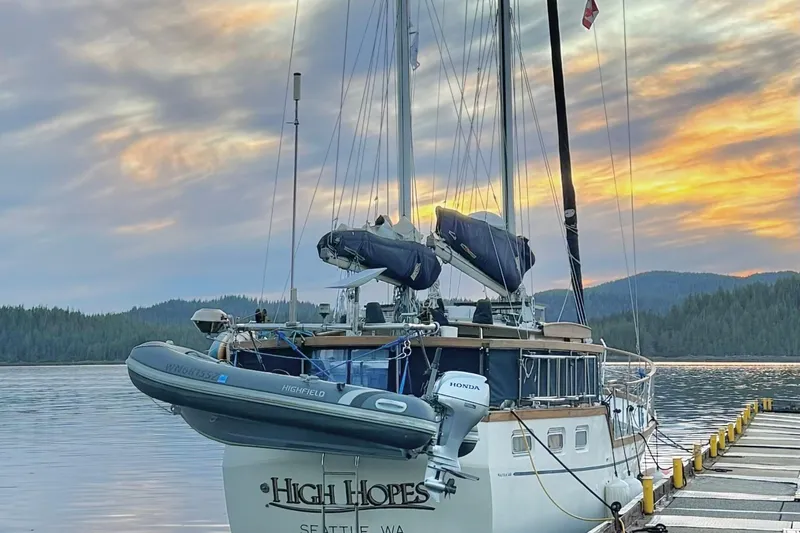 Slide: The Image of 1980 Nauticat Pilothouse sailboat docked at sunset with scenic mountain backdrop. - 51
