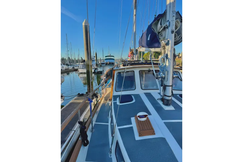 Slide: The Image of 1980 Nauticat Pilothouse sailboat docked in a marina under clear blue skies. - 54