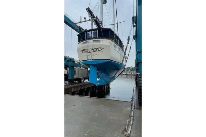 Slide: The Image of 1980 Nauticat Pilothouse sailboat "High Hopes" being lifted at a marina. - 55