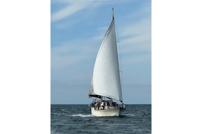 Slide: The Image of 1980 Nauticat Pilothouse sailboat navigating open sea under clear skies. - 56