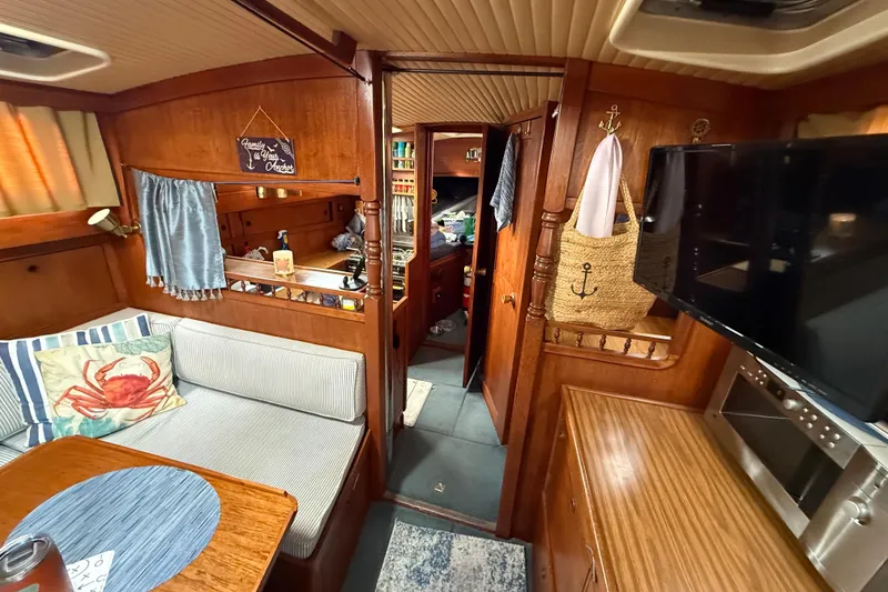 Slide: The Image of 1980 Nauticat Pilothouse interior with cozy seating, nautical decor, and wooden finishes. - 8