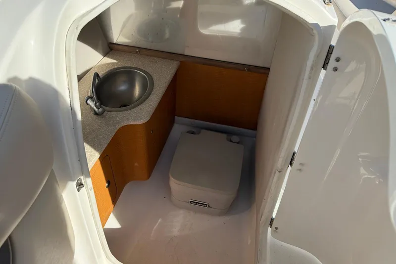 Slide: The Image of 2006 Chaparral 256 SSi boat interior with sink and compact toilet. - 8