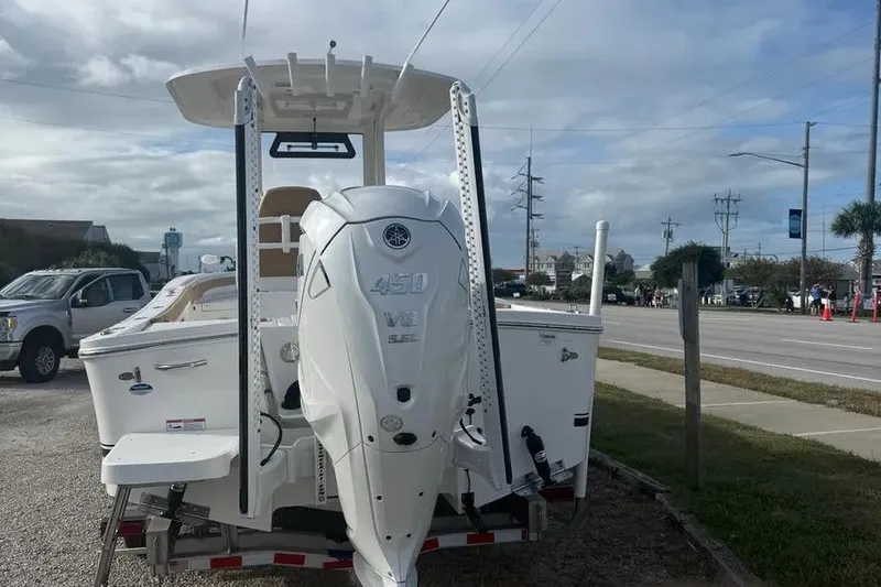 Slide: The Image of 2025 Regulator 26XO boat with powerful 450 V8 engine, parked near a road. - 2