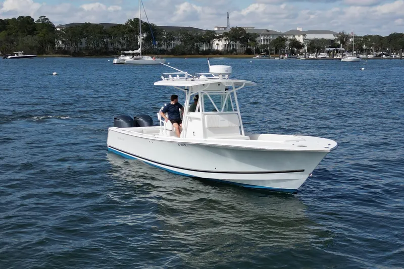 Slide: The Image of 2008 Regulator 32 Forward Seating boat cruising on a calm lake with scenic background. - 4