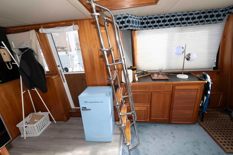 Slide: The Image of 1988 Chris-Craft 46 Constellation interior with wood paneling, ladder, and vintage Frigidaire fridge. - 10
