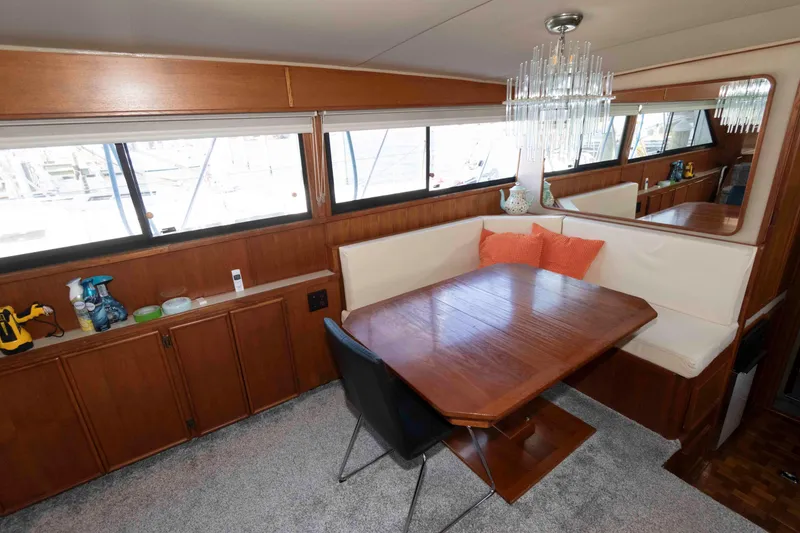 Slide: The Image of 1988 Chris-Craft 46 Constellation yacht interior with dining area, wood finishes, and large windows. - 17
