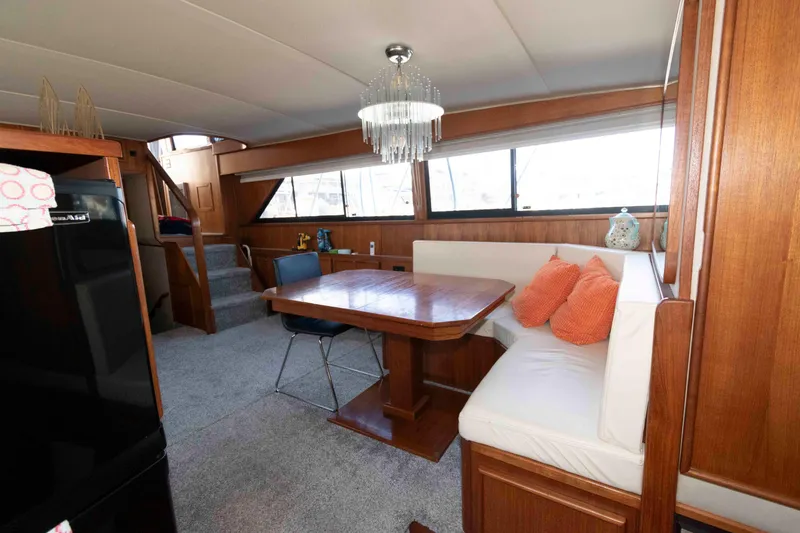 Slide: The Image of Interior of 1988 Chris-Craft 46 Constellation yacht with dining area and wooden furnishings. - 18