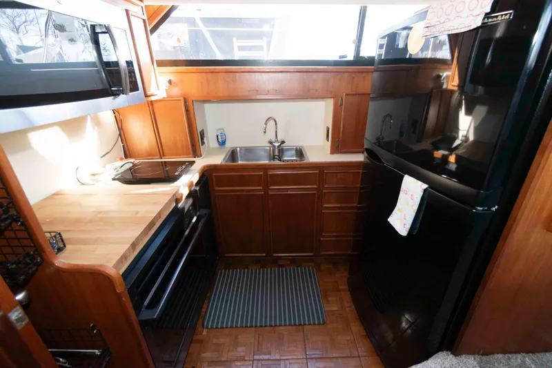 Slide: The Image of 1988 Chris-Craft 46 Constellation yacht kitchen with wood cabinetry and modern appliances. - 19