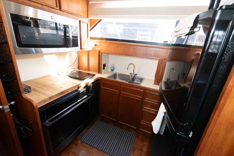 Slide: The Image of Kitchen area of 1988 Chris-Craft 46 Constellation yacht with modern appliances. - 20
