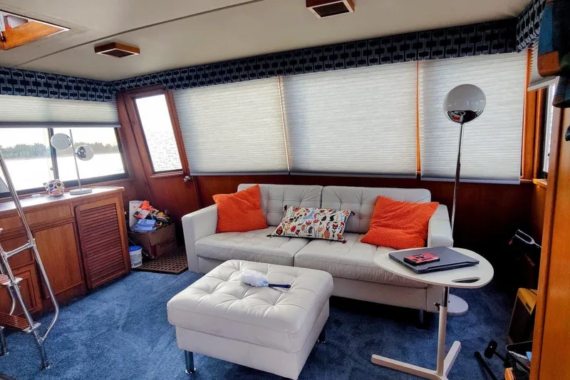 Slide: The Image of 1988 Chris-Craft 46 Constellation yacht deck with seating, docked on a serene lake. - 4
