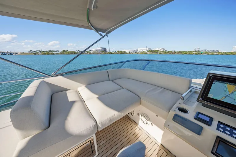 Slide: The Image of Luxurious 2019 Azimut S7 yacht deck with plush seating and navigation system, overlooking serene waters. - 18