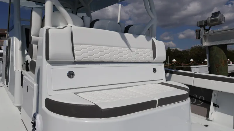 Slide: The Image of 2025 Yellowfin 39 Offshore boat with white cushioned seating, docked under a cloudy sky. - 32