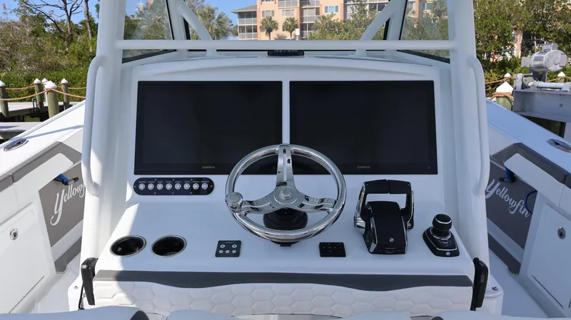 Slide: The Image of 2025 Yellowfin 39 Offshore boat dashboard with dual screens and steering wheel. - 37
