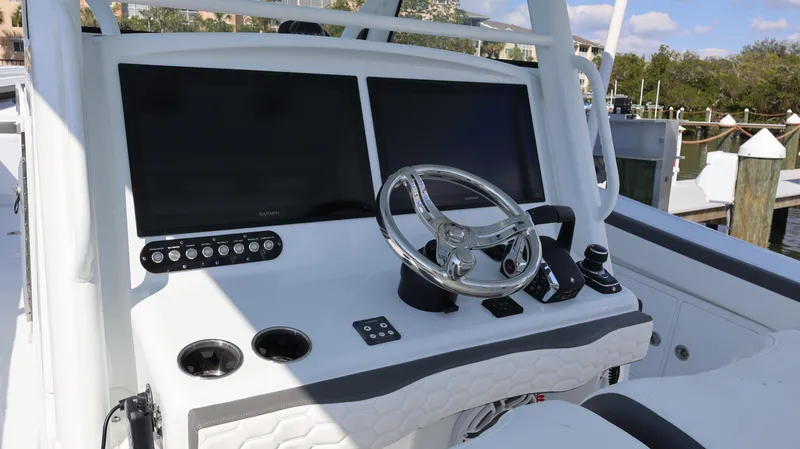 Slide: The Image of 2025 Yellowfin 39 Offshore boat dashboard with dual screens and steering wheel. - 39