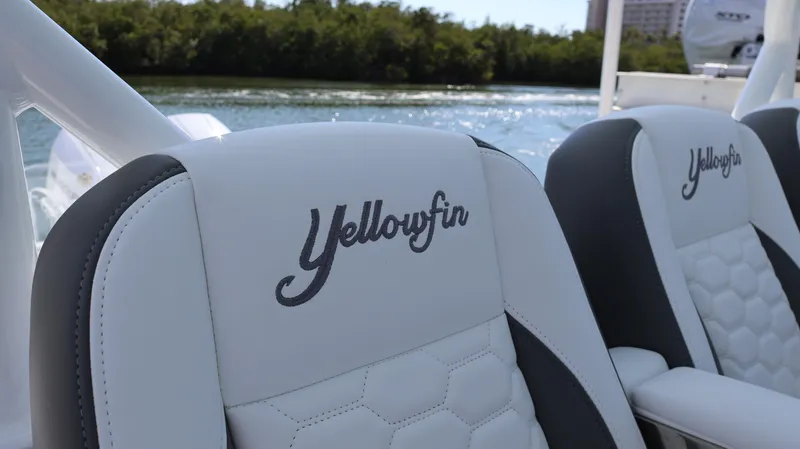 Slide: The Image of 2025 Yellowfin 39 Offshore boat seats with logo, on water background. - 47