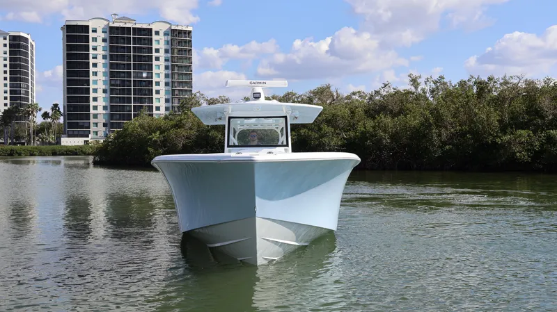 Slide: The Image of 2025 Yellowfin 39 Offshore boat on calm water with buildings in the background. - 8