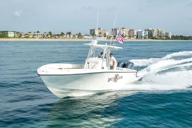 Slide: The Image of 2014 SeaVee 34 boat cruising near coastal buildings, American flag flying. - 12