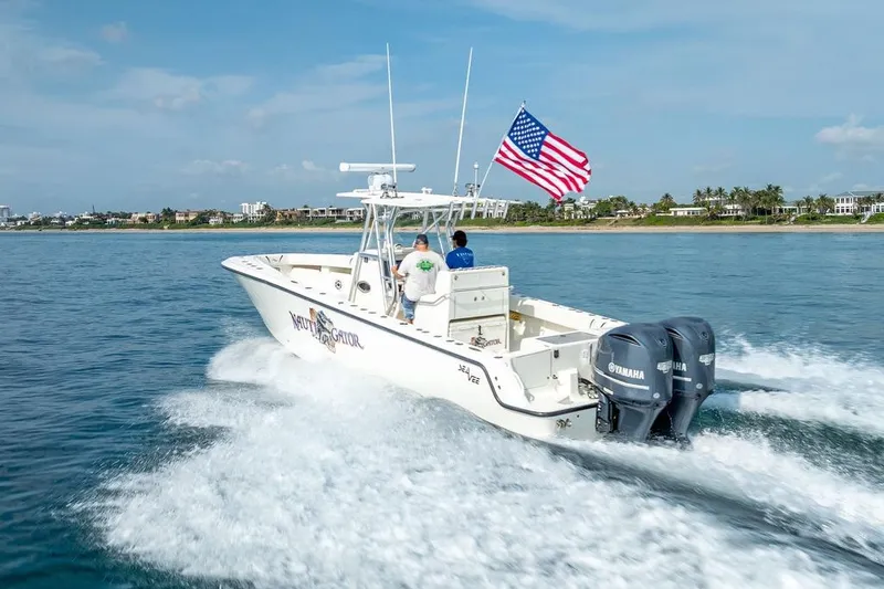 Slide: The Image of 2014 SeaVee 34 boat cruising with American flag, twin Yamaha engines, coastal background. - 17