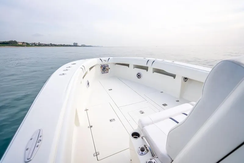 Slide: The Image of 2014 SeaVee 34 boat, spacious deck, calm ocean view, sleek white design. - 20