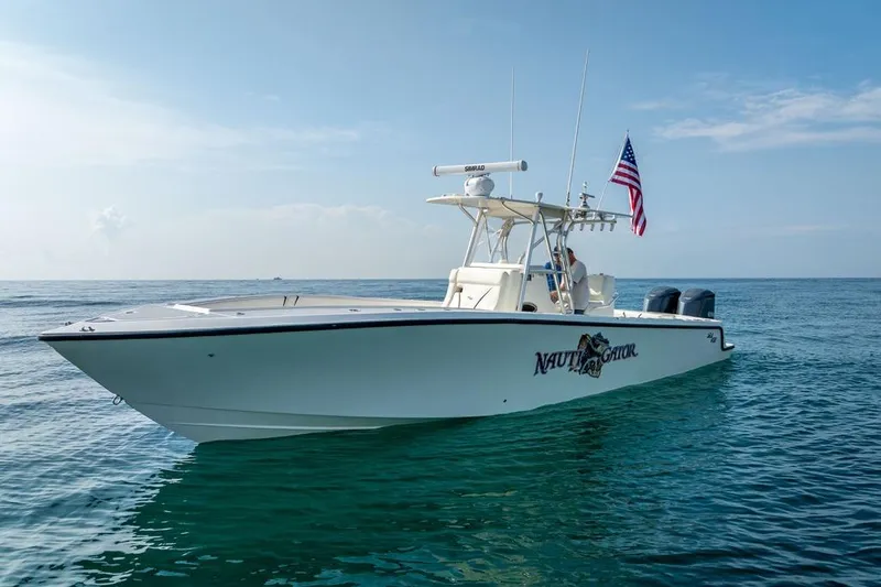 Slide: The Image of 2014 SeaVee 34 boat on calm ocean with American flag, clear sky background. - 3