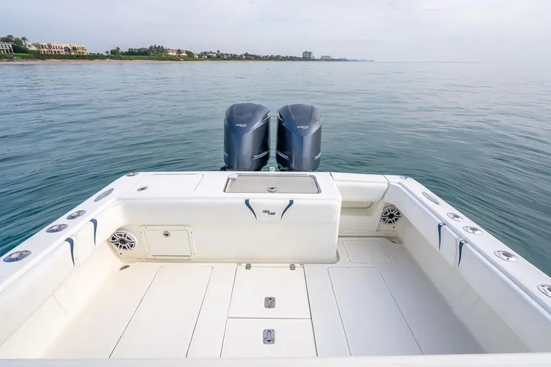Slide: The Image of 2014 SeaVee 34 boat with dual engines, spacious deck, and coastal view. - 42