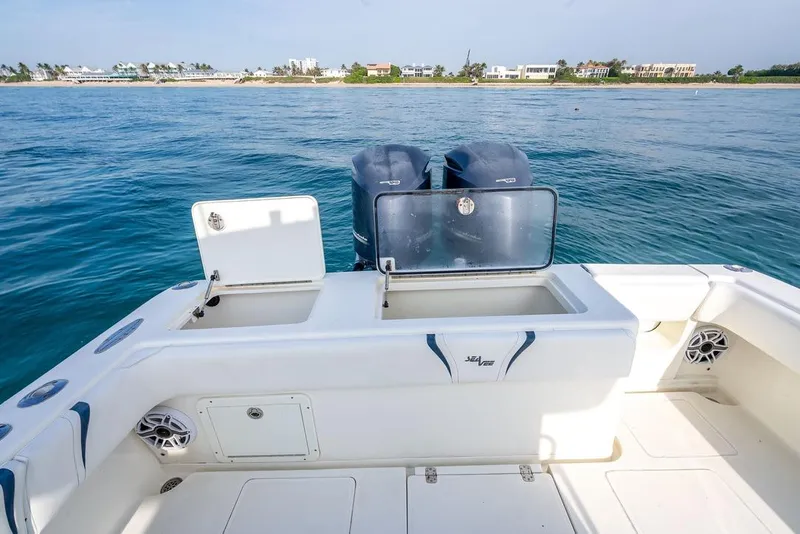 Slide: The Image of 2014 SeaVee 34 boat with dual engines, open deck, and coastal view. - 43