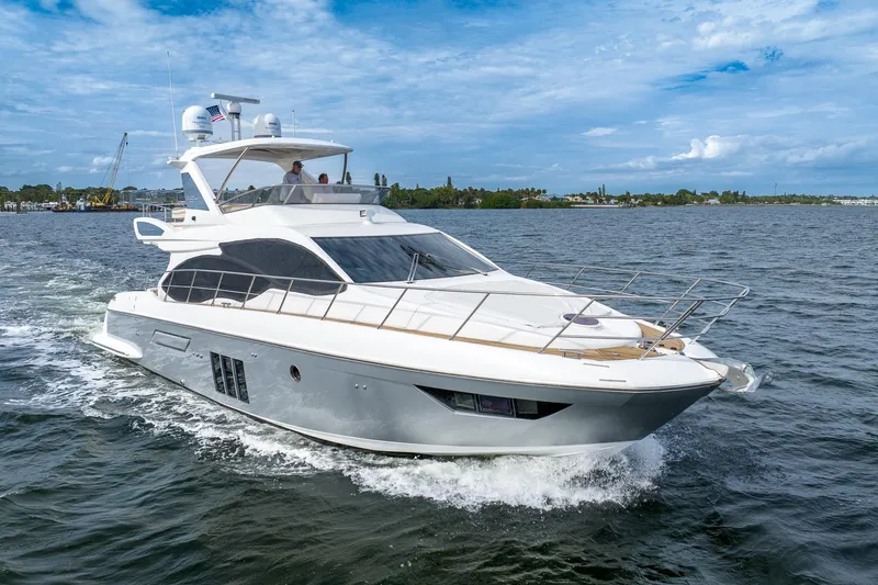 The Image of 2014 Azimut 54 Flybridge yacht cruising on open water under a clear sky. - 0