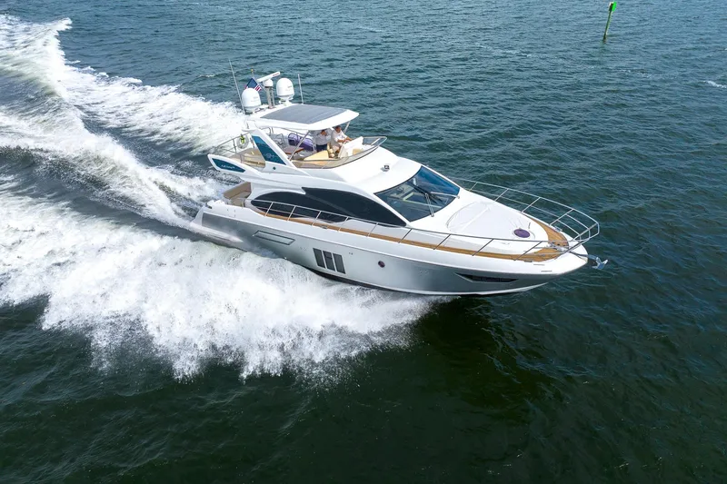 Slide: The Image of 2014 Azimut 54 Flybridge yacht cruising on open water, creating a dynamic wake. - 12