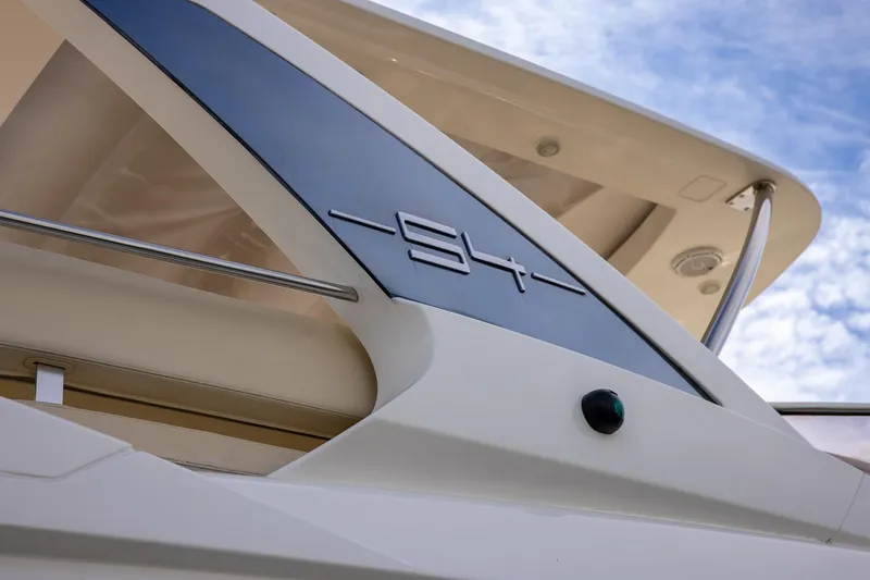 Slide: The Image of 2014 Azimut 54 Flybridge yacht detail with sleek design against blue sky. - 14