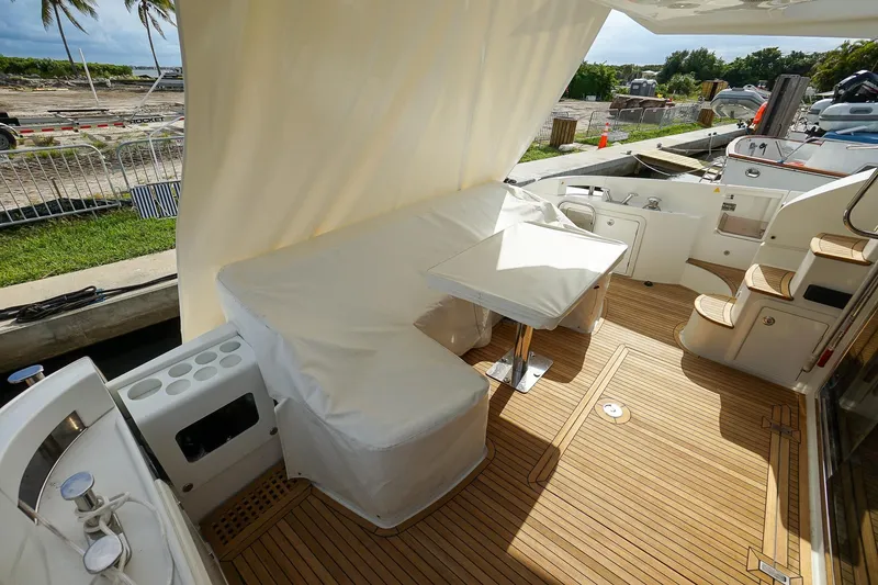 Slide: The Image of 2014 Azimut 54 Flybridge yacht deck with seating, table, and wooden flooring. - 21