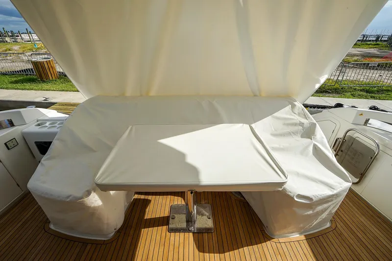 Slide: The Image of 2014 Azimut 54 Flybridge yacht deck with covered seating and table. - 22