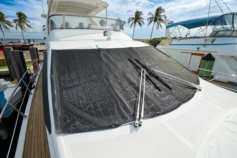 Slide: The Image of 2014 Azimut 54 Flybridge yacht with covered windshield, docked near palm trees. - 23