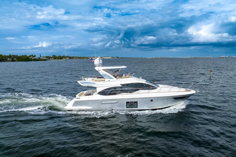 Slide: The Image of 2014 Azimut 54 Flybridge yacht cruising on open water under a cloudy sky. - 3