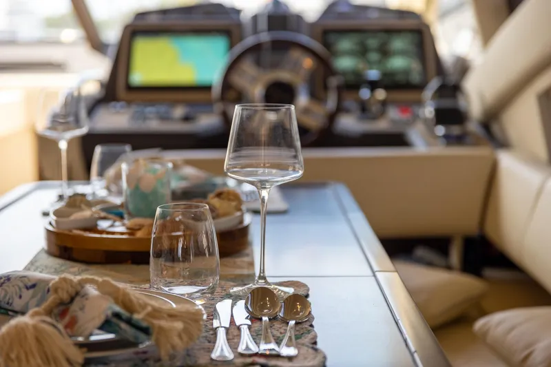 Slide: The Image of Luxurious dining setup on 2014 Azimut 54 Flybridge yacht, featuring elegant glassware and cutlery. - 61