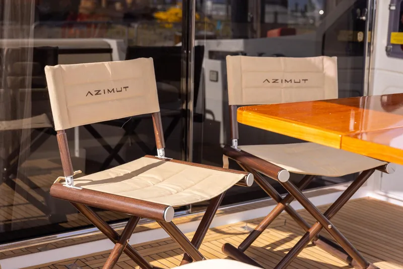 Slide: The Image of Azimut 54 Flybridge 2014 yacht deck with branded chairs and wooden table. - 65